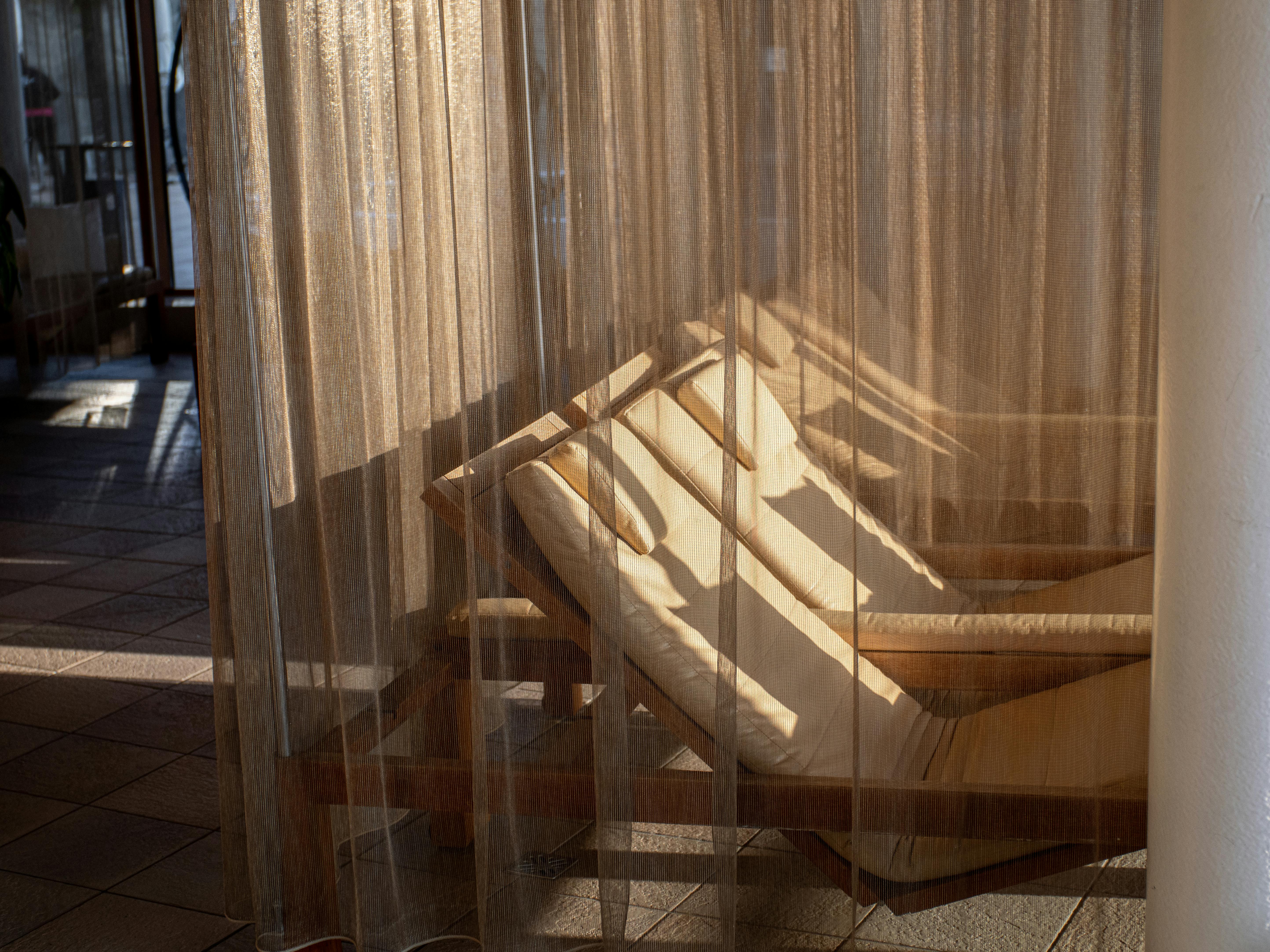 Snuggling behind a curtain.