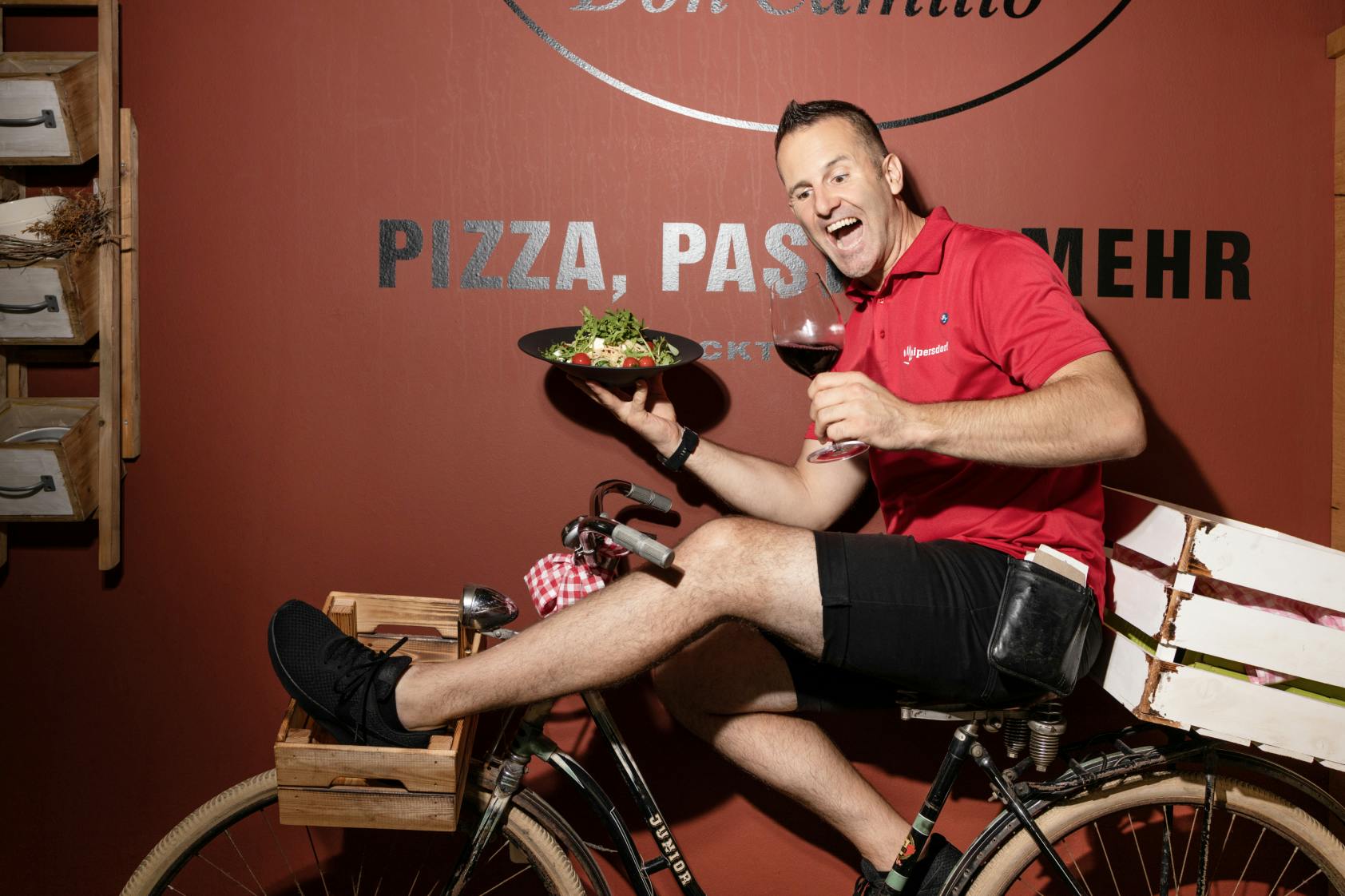 A waiter juggles a plate on a bicycle.