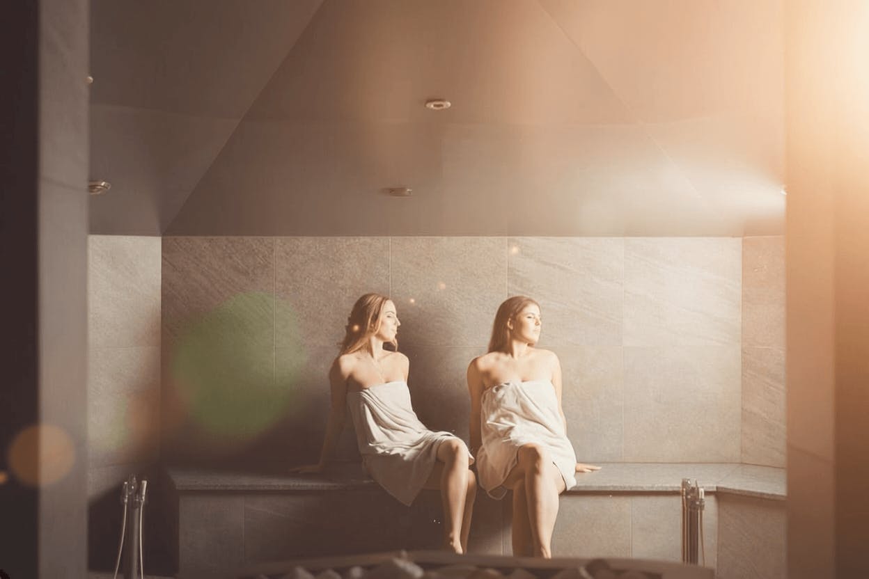 Two friends are sitting in the steam room.