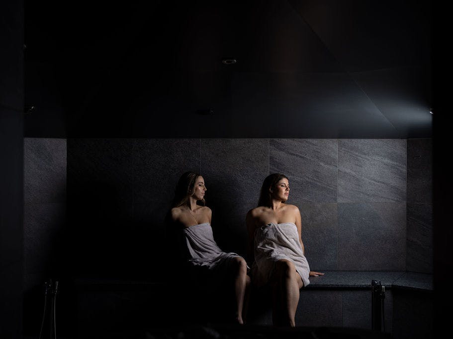 Two friends are sitting in the steam room.