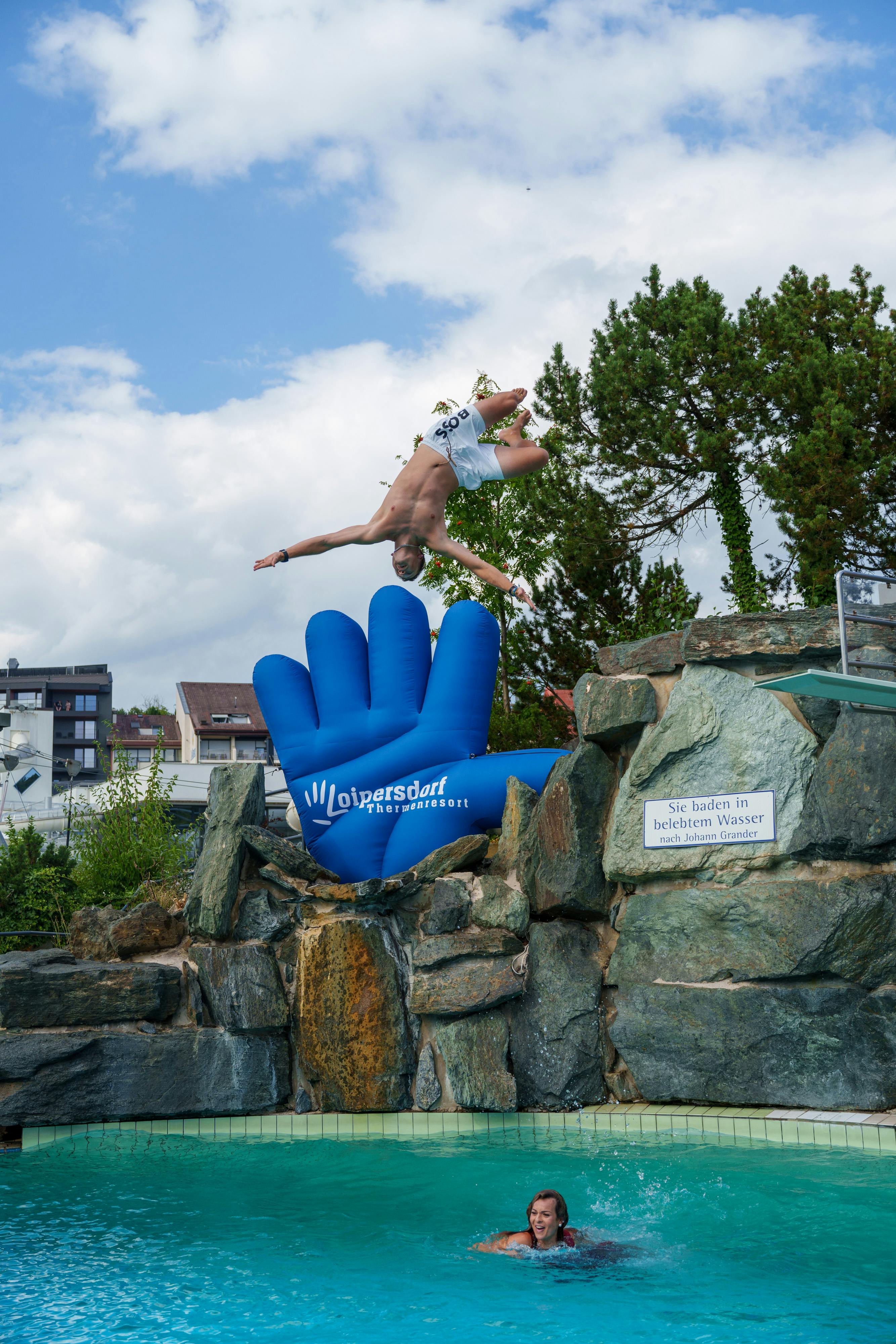 Ein Mann macht einen großen Salto ins Acapulco Becken.