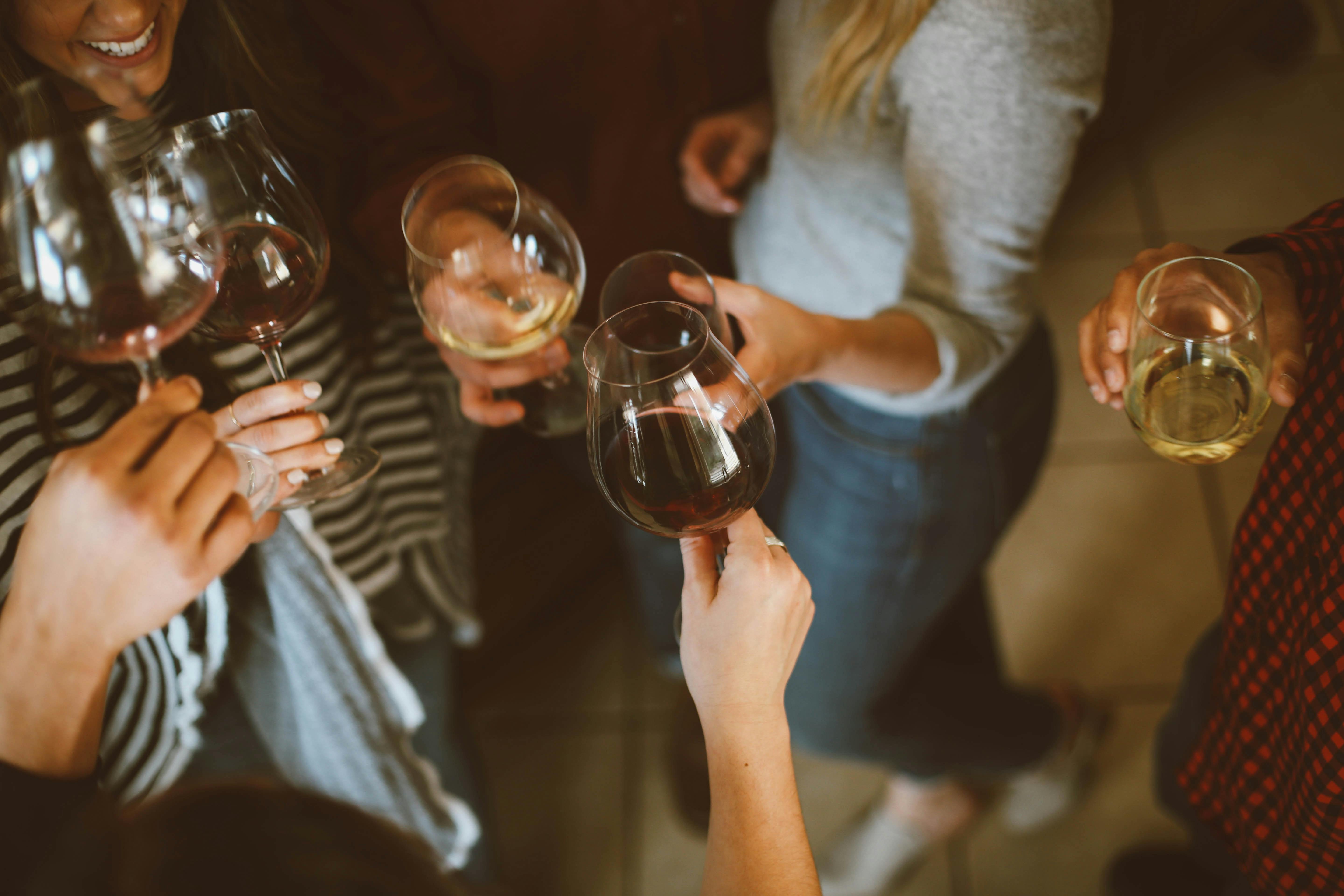Freunde die mit einem Glas Wein anstoßen. 