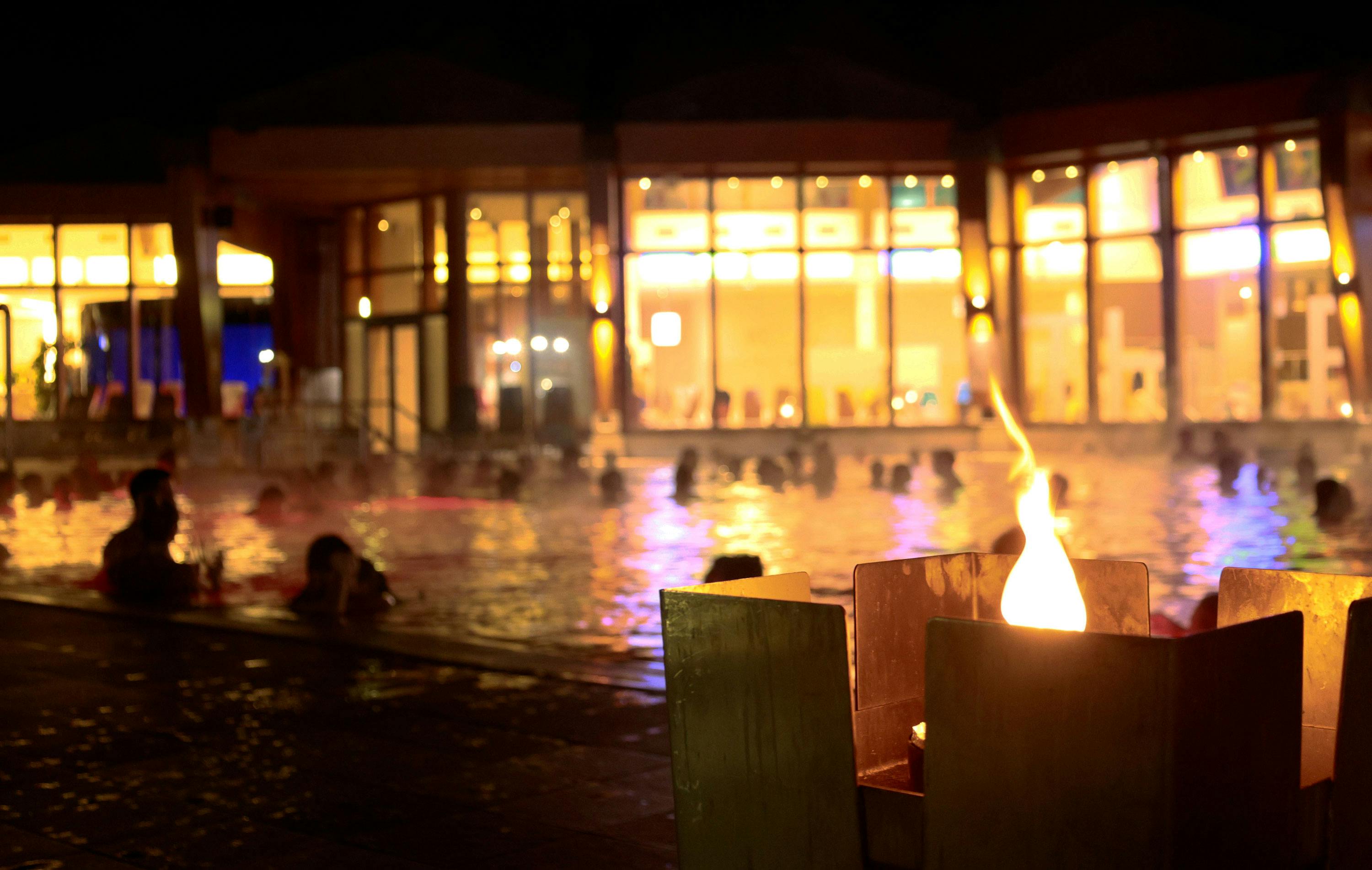 Feuerkörbe sorgen für romantische Stimmung - im Hintergrund das Thermalwasserbecken im Thermenresort Loipersdorf. 