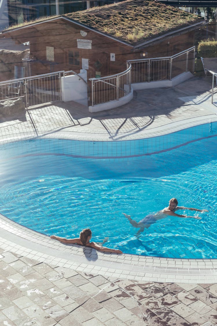 Zwei Badende im großzügigen Pool des Außenbereichs im Schaffelbad.