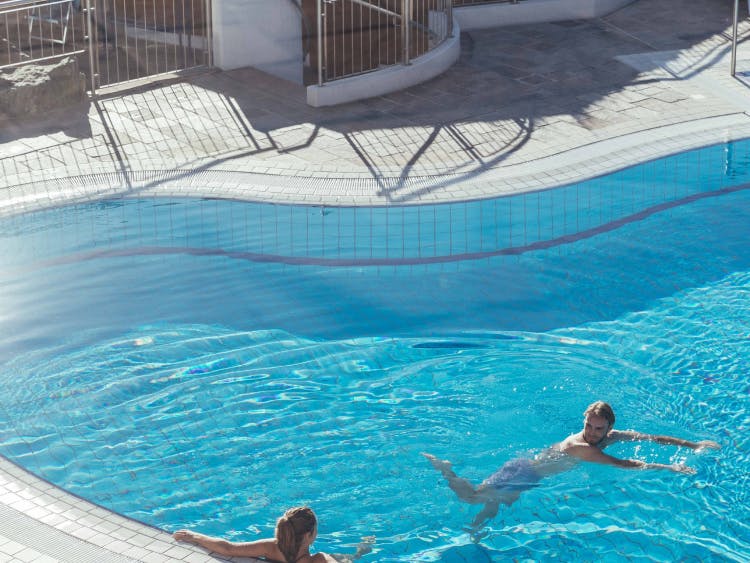 Zwei Badende im großzügigen Pool des Außenbereichs im Schaffelbad.