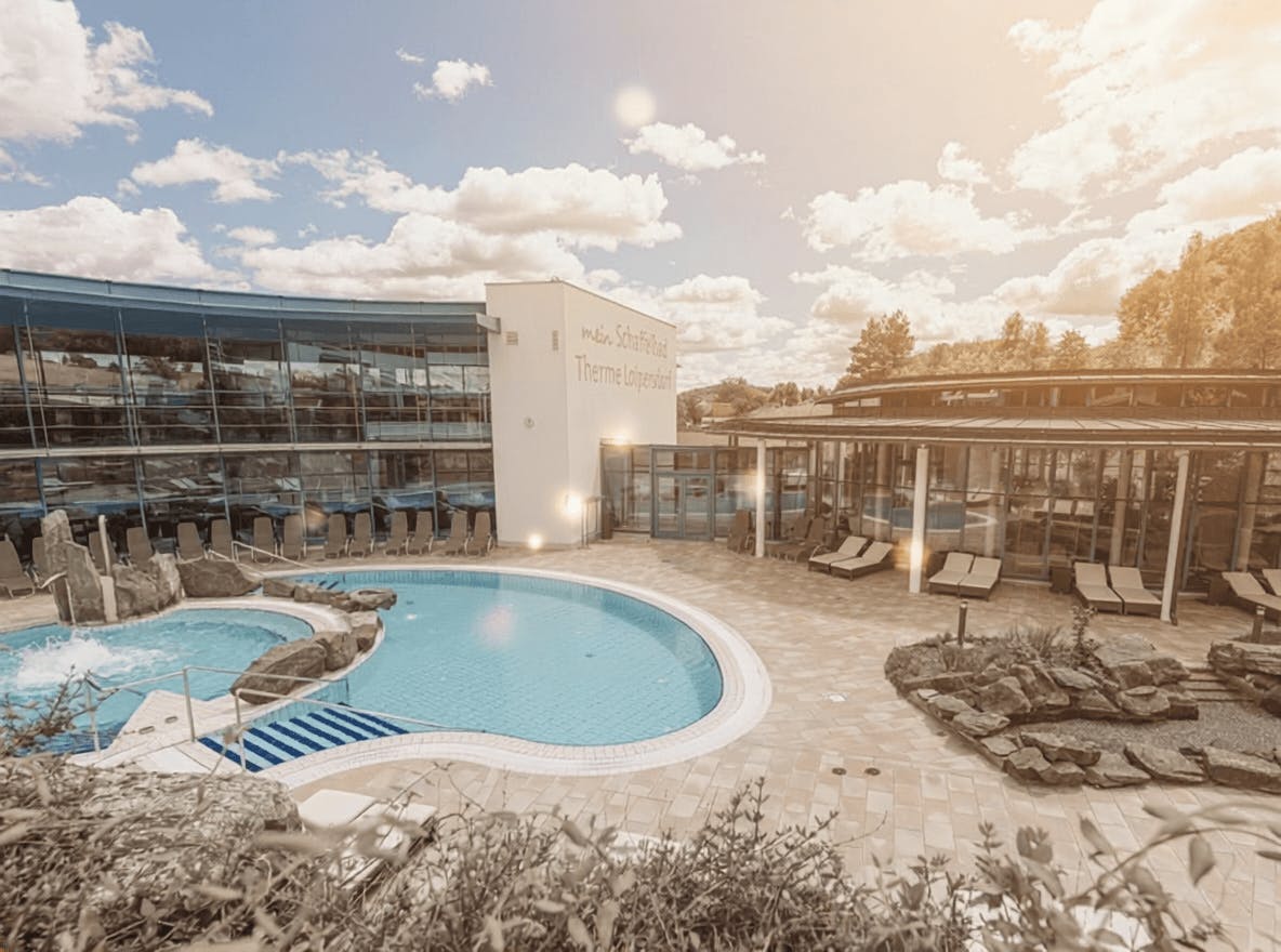 The rock pool and lake pavilion at Schaffelbad in the sunshine.