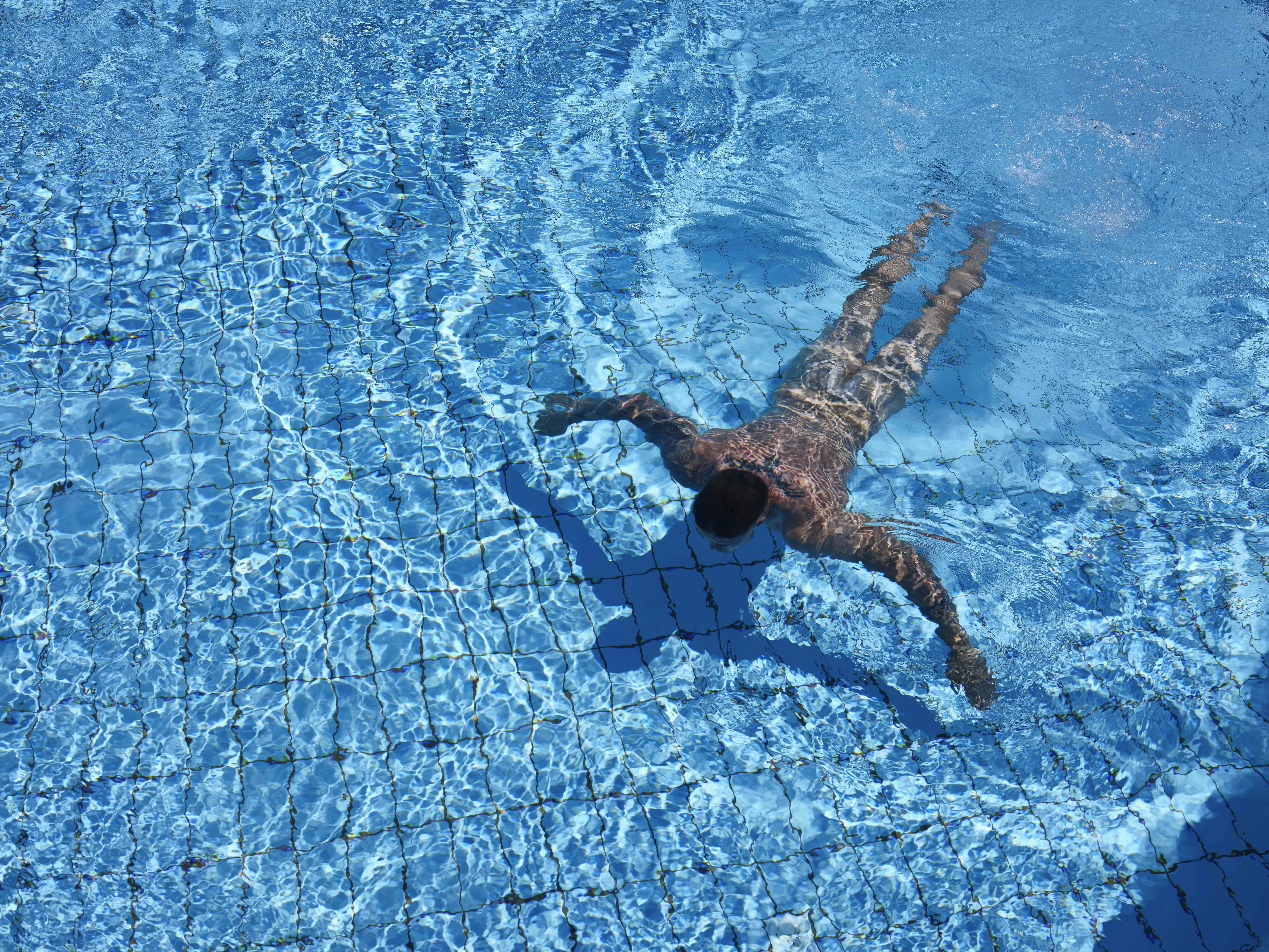 Ein Mann schwimmt nackt im Wasser.