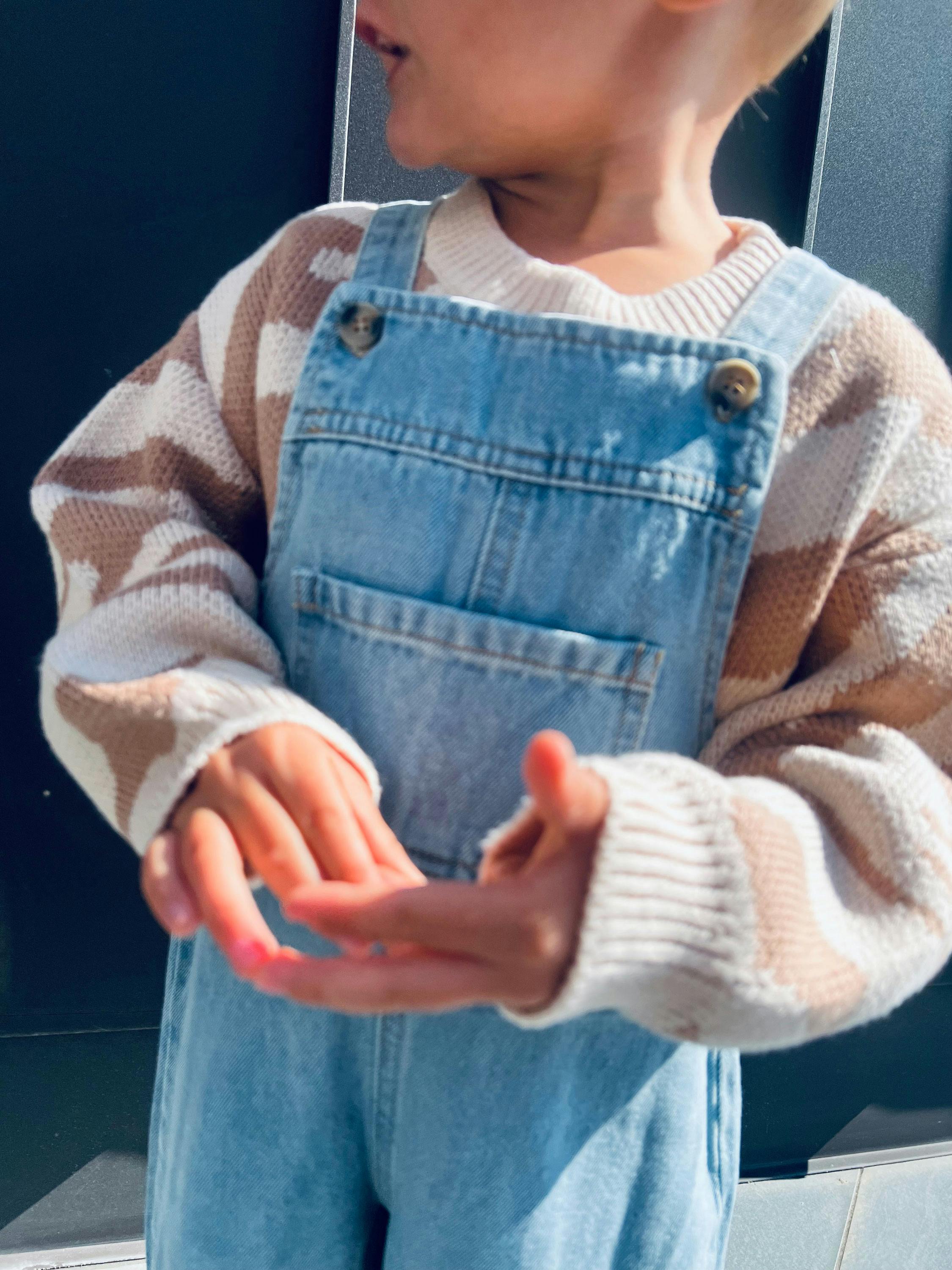 Regal mit weißen und rosa Taschen, gestreiften Schalen, weißen Tassen und mehreren weißen Kartons in einem Geschäft.