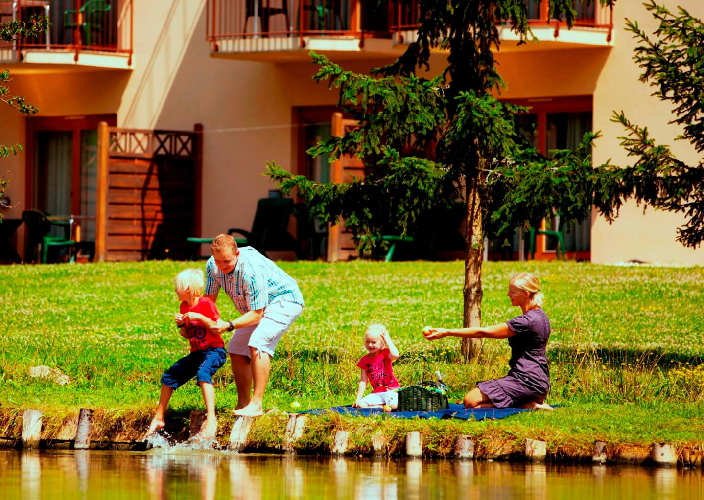 Eine Familie spielt im Garten des Familienhotels Krainz.