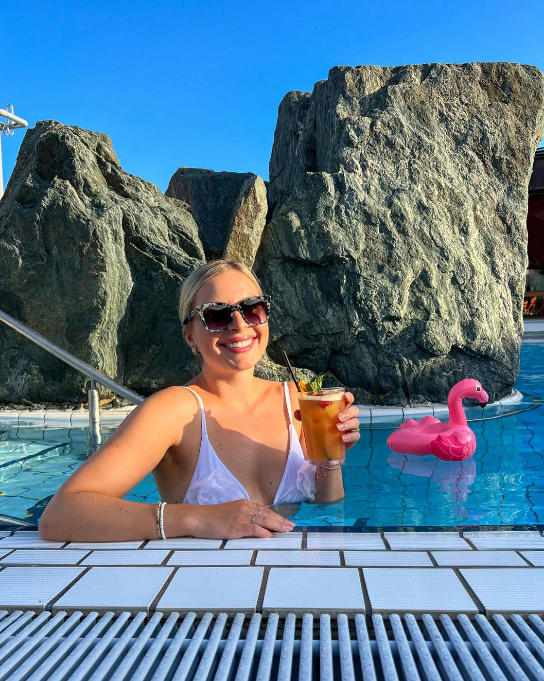 Frau trinkt Cocktail im Pool. 