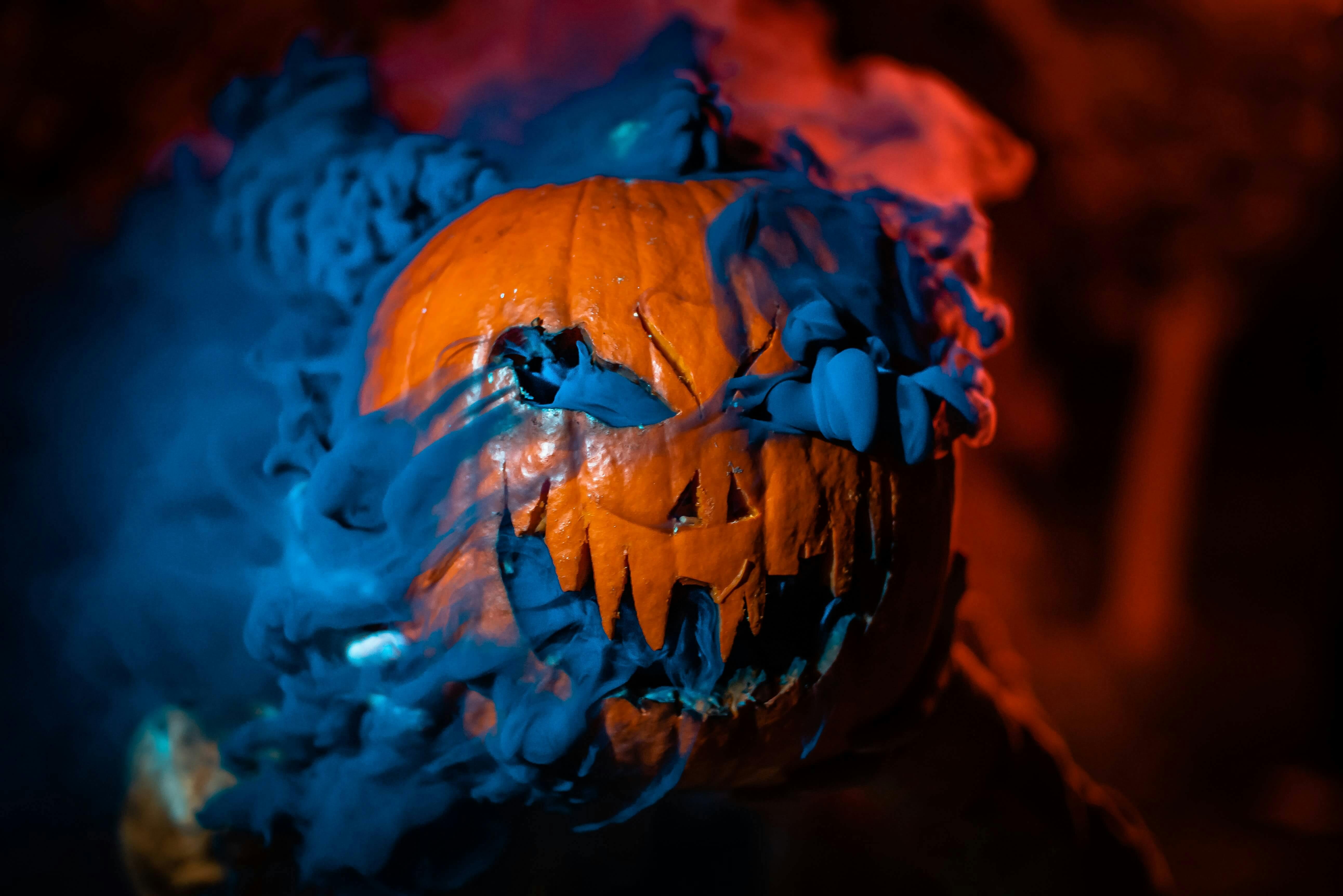 Ein schauriger Halloweenkürbis vor düsteren Hintergrund.
