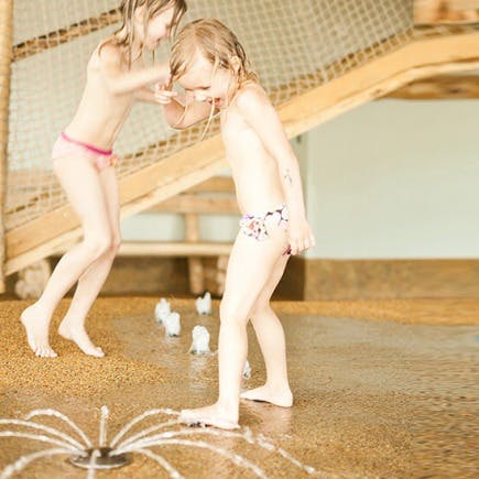 Zwei Kleinkinder spielen mit Wasser.