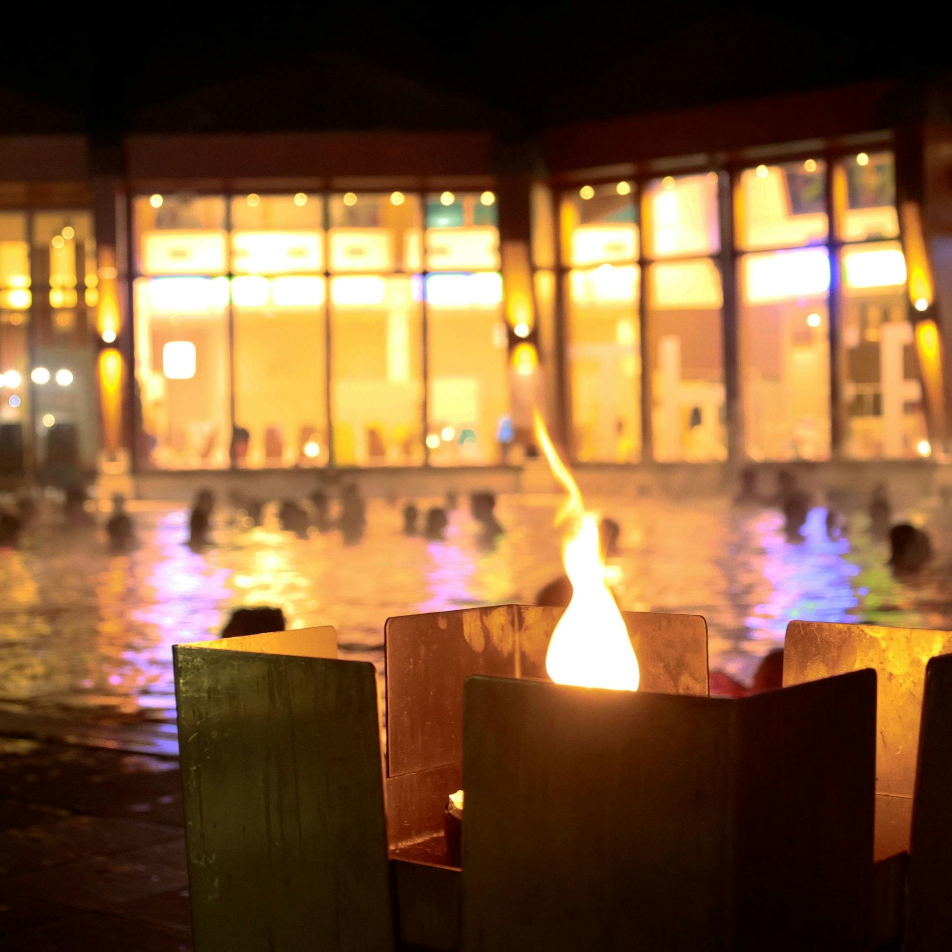 Feuerkörbe sorgen für romantische Stimmung - im Hintergrund das Thermalwasserbecken im Thermenresort Loipersdorf. 